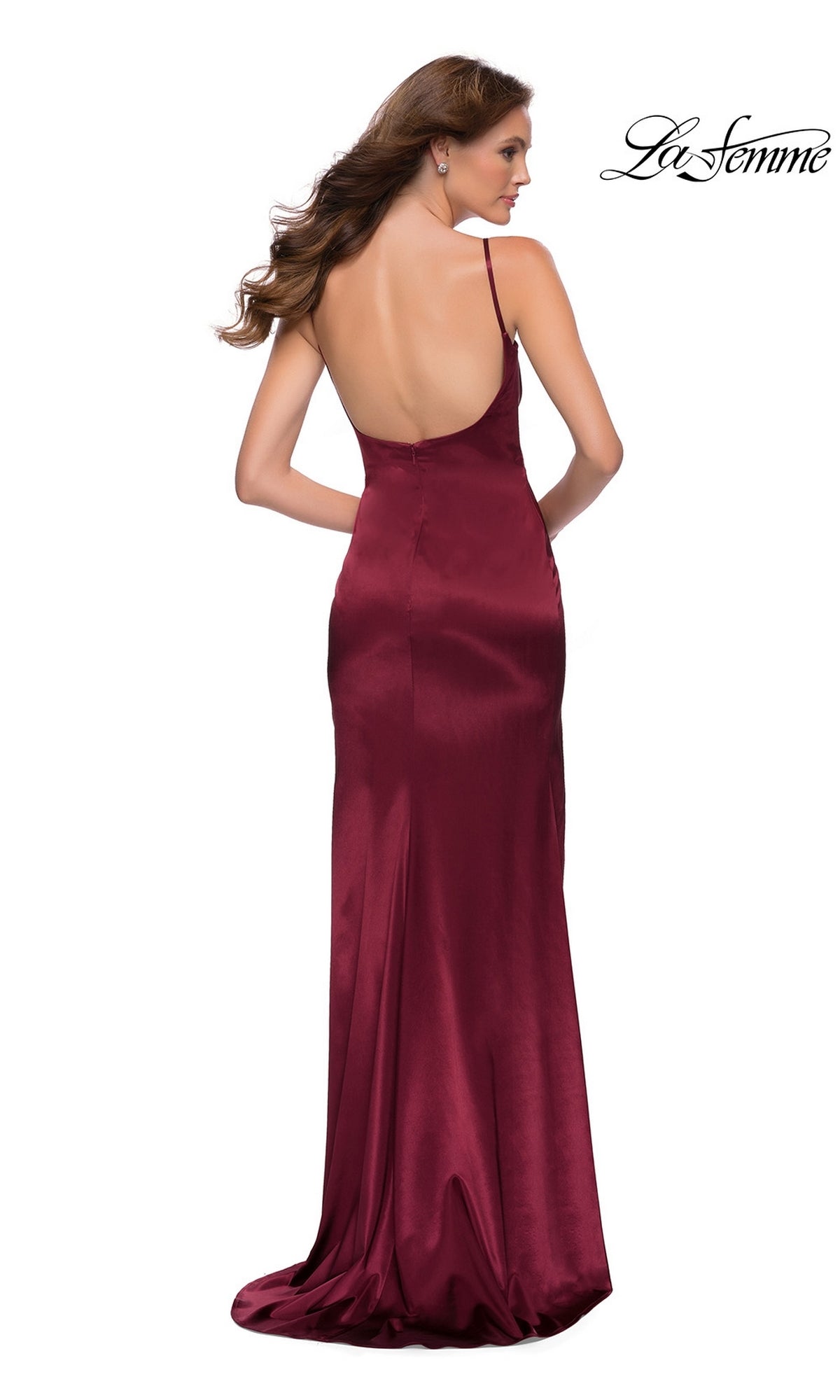 A woman faces away in the La Femme Open-Back Simple Long Prom Dress 29945, a floor-length burgundy gown with thin straps and a backless design, set against a white background.